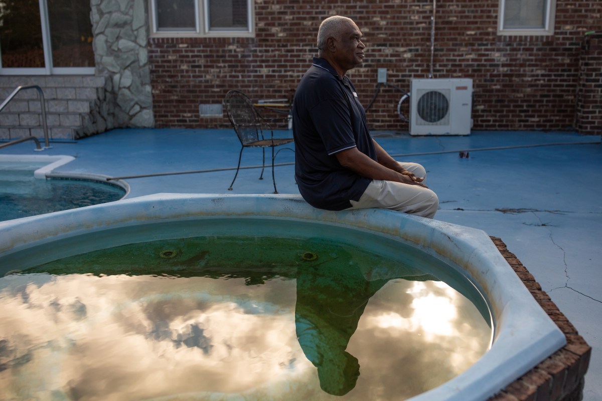 Carl Parker sits beside a small pool outside his home